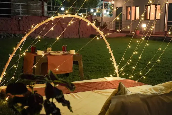 A garden table surrounded by warm evening lights