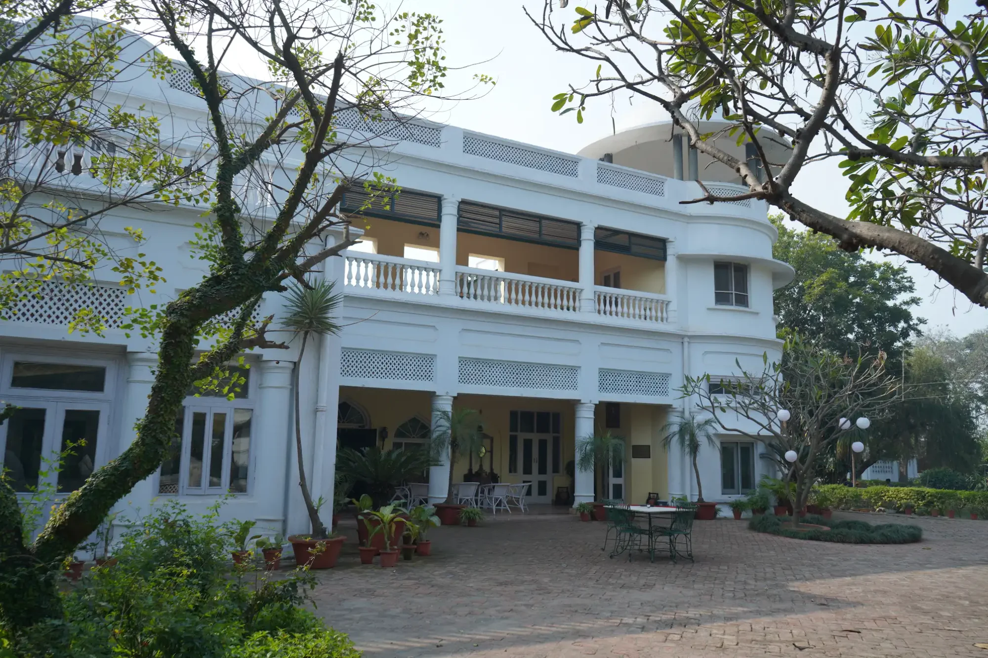 White facade framed by mature trees