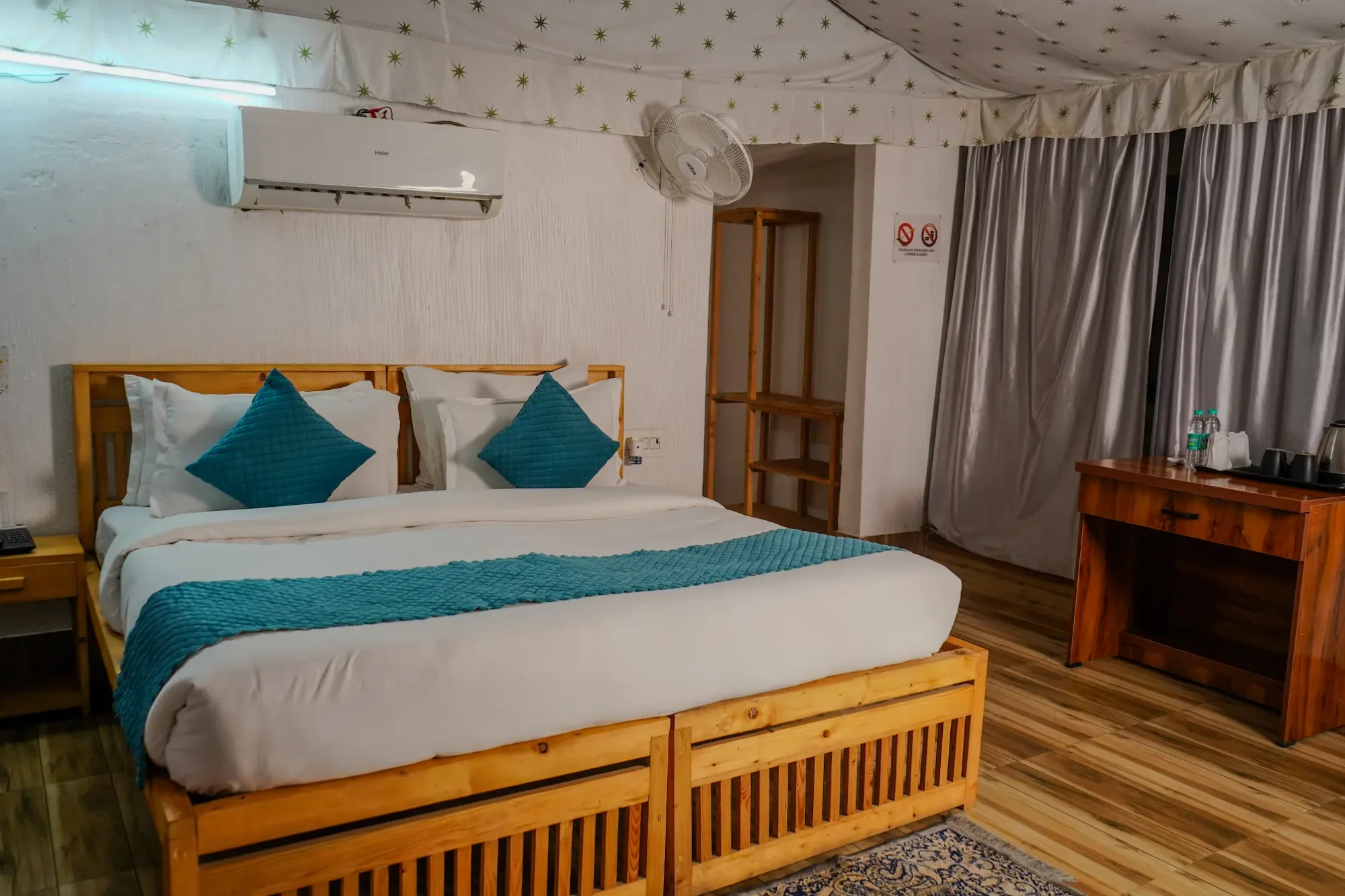 Guest bedroom with teal bedding and a patterned ceiling